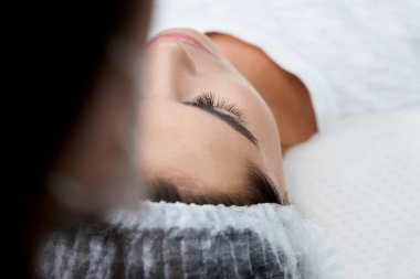 Kirpik uzatma prosedürü. Uzun kirpikli kadın gözü