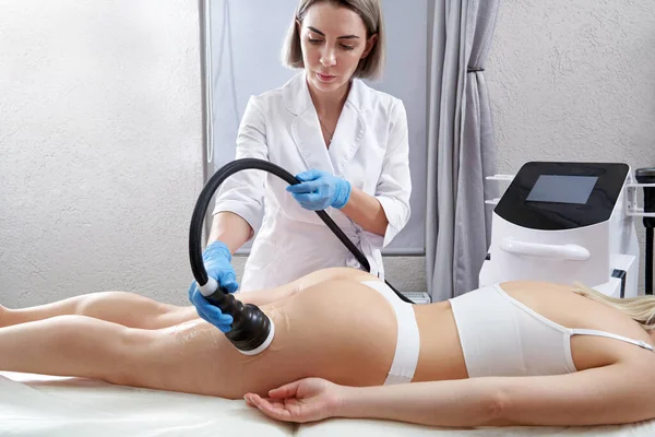Kadın güzellik salonunda anti-selülit ve anti-yağ terapisi görüyor. Donanım kozmetolojisi. Vücut bakımı. Spa tedavisi. Ultrason boşluğu vücut hatları