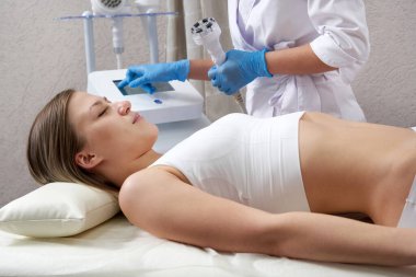 Donanım kozmetolojisi. Genç bir kadın güzellik salonunda güzellik tedavisi görüyor.