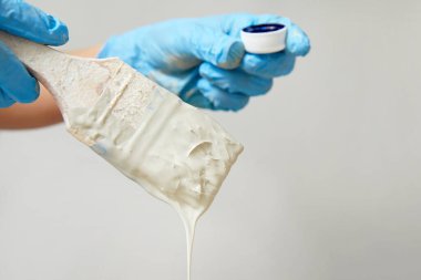 Boya fırçası ve boya kullanarak eldiven takan el manzarası