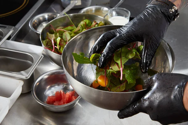 Close-up de mãos de chef preparando salada em uma cozinha de restaurante — Fotografia de Stock