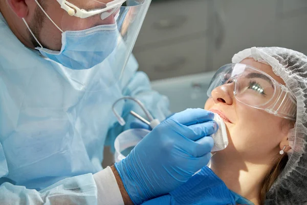 Dentist cleaning mouth of patient after treatment — 图库照片