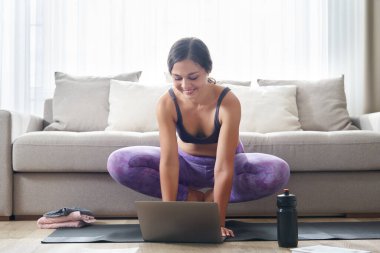 Güzel Atletik Kadın Yoga Matta Oturuyor Bazı egzersizlerden sonra Protein içeceği ya da su