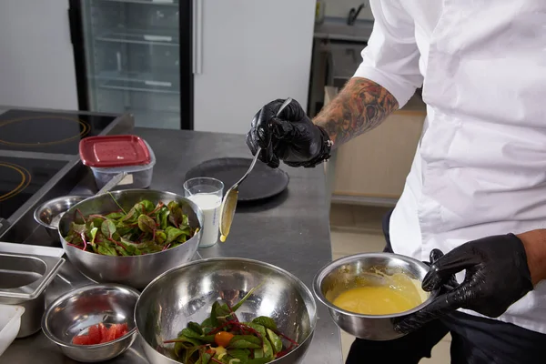 Närbild av kock händer förbereda sallad hälla sås i ett restaurangkök — Stockfoto