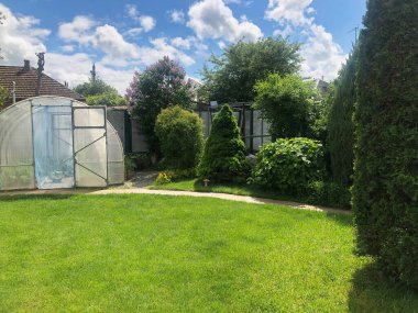 Bahçede yeşil çimenli küçük kemerli sera