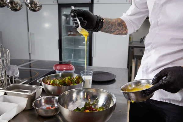 Närbild av kock händer förbereda sallad hälla sås i ett restaurangkök — Stockfoto