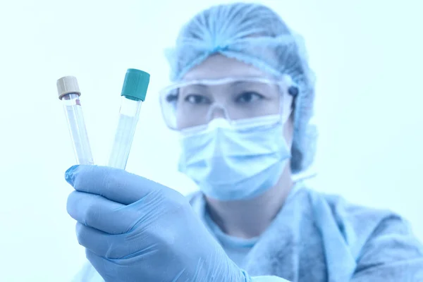 Kvinnlig forskare som håller två provrör i laboratorium för forskning och analys. Koncept för hälso- och sjukvård. Blåtonad — Stockfoto