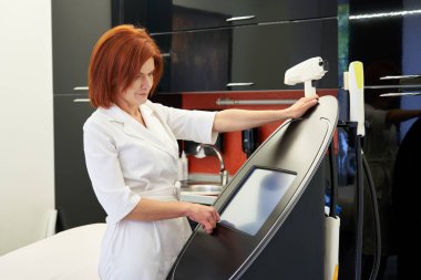 Kozmetik uzmanı tıbbi klinikte Smas ekipmanlarıyla duruyor.