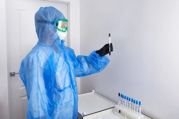 Tecnólogo médico que sostiene el hisopo COVID-19, usando traje protector del PPE, máscara, guantes. Tubo de ensayo para tomar la muestra de paciente OP NP, proceso de protocolo de prueba de ADN PCR — Foto de Stock