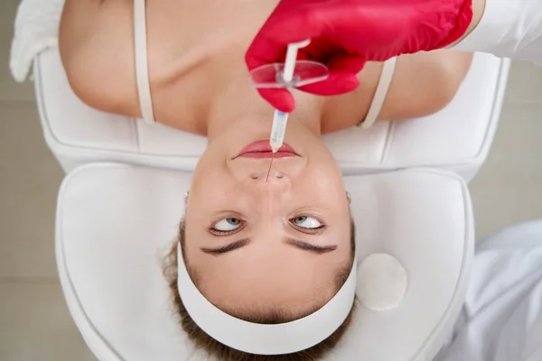 美容院的美容师在鼻腔内注射注射器。整容更新面部治疗 — 图库照片