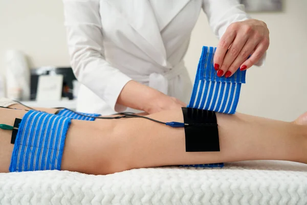 在美容院里对一个女人的腿进行肌萎缩的过程。用电刺激身体，减轻超重 — 图库照片