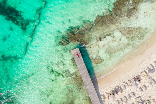 Luftaufnahme einer Frau, die an einem sonnigen Sommertag in Cancun, Mexiko, auf einem Holzsteg liegt, von oben. Junge sexy Frau im roten Badeanzug im Sommer in der Karibik. Sommerferienkonzept — Stockfoto