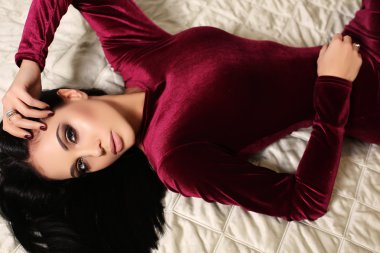 beautiful sensual woman  with dark hair wears elegant dress,posing in bedroom