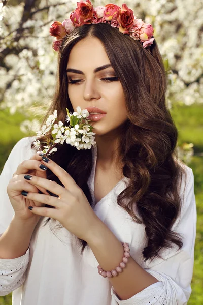 Gorgeous sensual woman with dark hair in elegant dress posing in blossom garden — Stockfoto