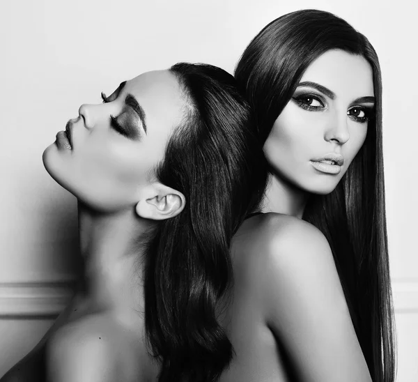 Duas belas mulheres jovens com cabelo escuro e maquiagem à noite — Fotografia de Stock