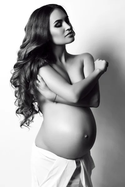 Belle femme enceinte avec de longs cheveux noirs, posant en studio — Photo