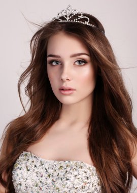 Koyu saçlı güzel kadın zarif elbise ve değerli taç giyer