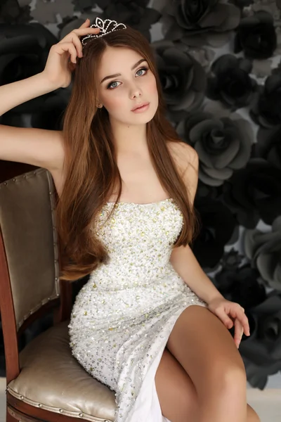 Mulher bonita com cabelo escuro usa vestido elegante e coroa preciosa — Fotografia de Stock