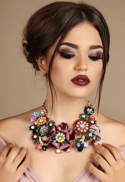 sexy woman with dark hair and bright makeup, with necklace