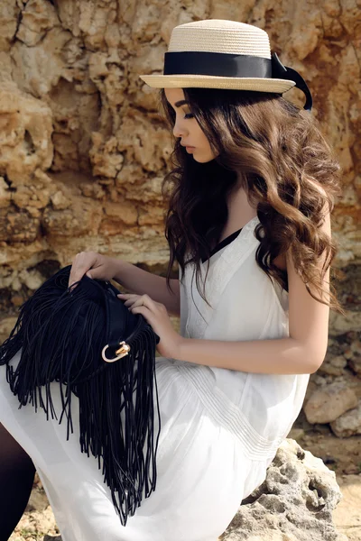 Koyu saçlı güzel kız rahat şık kıyafetler ve şapka giyer 