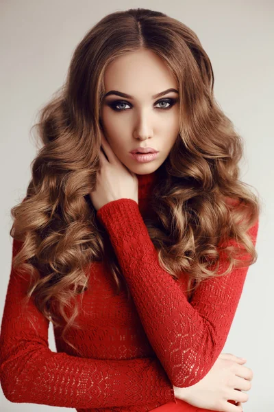 Όμορφη νεαρή γυναίκα με σκούρα μαλλιά σε κομψό κόκκινο φόρεμα — Φωτογραφία Αρχείου
