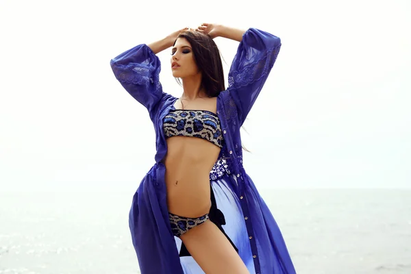 Gorgeous woman with dark hair in elegant swimsuit posing on beach — Stock Photo, Image