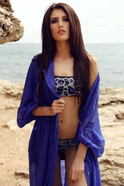 Underbara kvinna med mörkt hår i elegant baddräkt poserar på stranden — Stockfoto