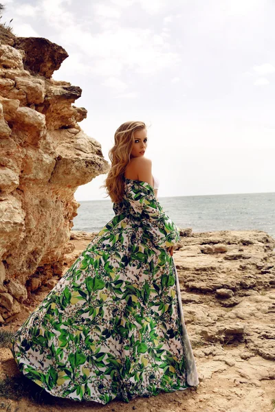 Hermosa mujer con el pelo rubio en vestido elegante posando en la playa —  Fotos de Stock