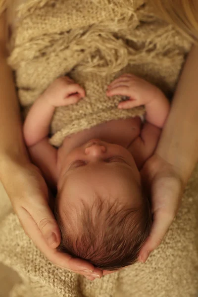Niña recién nacida durmiendo bajo una manta acogedora en las manos de mamá —  Fotos de Stock