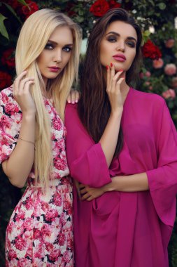 yaz bahçesinde gül çalı yanında poz zarif parlak elbiseler şehvetli kadınlar 