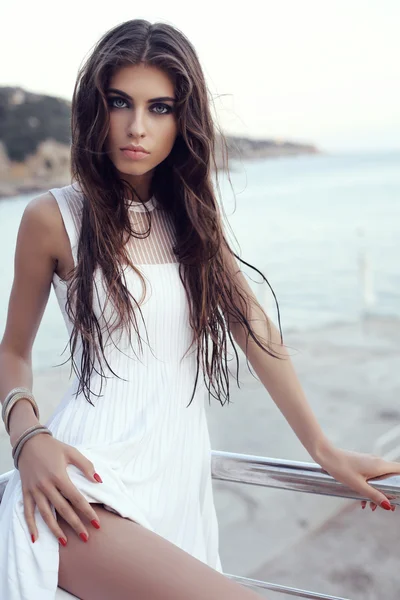 Mulher linda com cabelo escuro em vestido elegante na praia — Fotografia de Stock