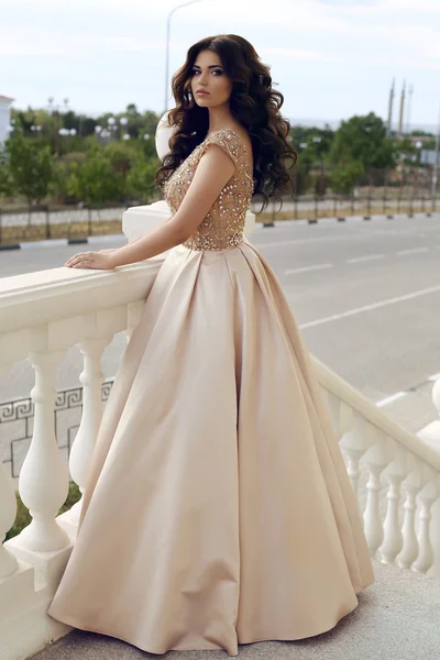 Wunderschöne Frau mit dunklen Haaren im luxuriösen eleganten Kleid — Stockfoto