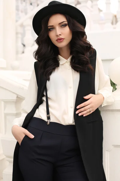 Kvinna med mörkt hår i eleganta kläder och hatt — Stockfoto