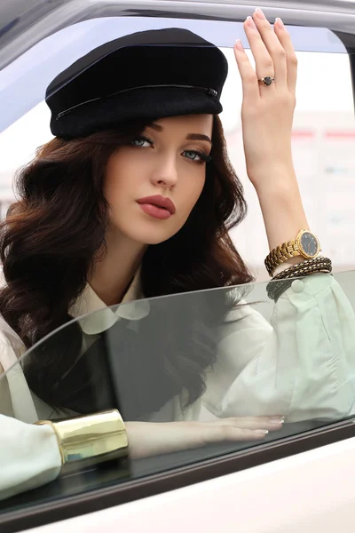 Woman with dark hair in elegant clothes sitting in car — Stock Photo, Image