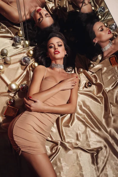 エレガントなドレスで暗い髪の美しい女性のファッション写真は ミラーに反映黄金の床にある — ストック写真