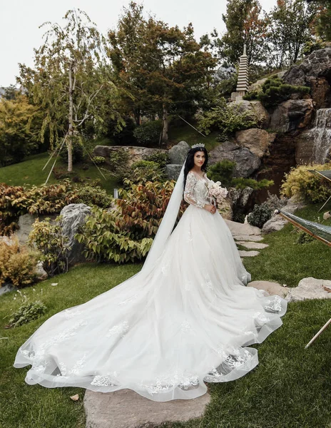 秋天公园里穿着华丽婚纱 一头乌黑头发的漂亮新娘的户外时尚照片 — 图库照片