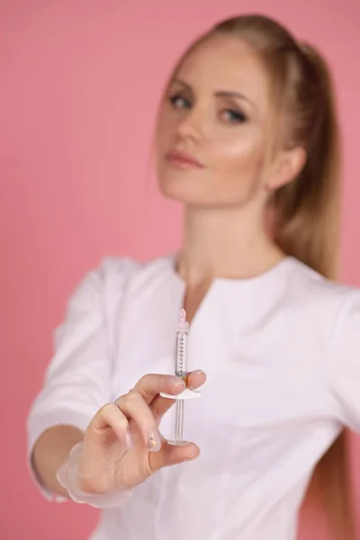 注射器を装着した白い医療用ローブ姿の美女コメットロジストのファッションスタジオ写真 — ストック写真