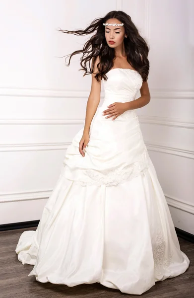 Beautiful young bride in wedding dress posing at studio — Stockfoto