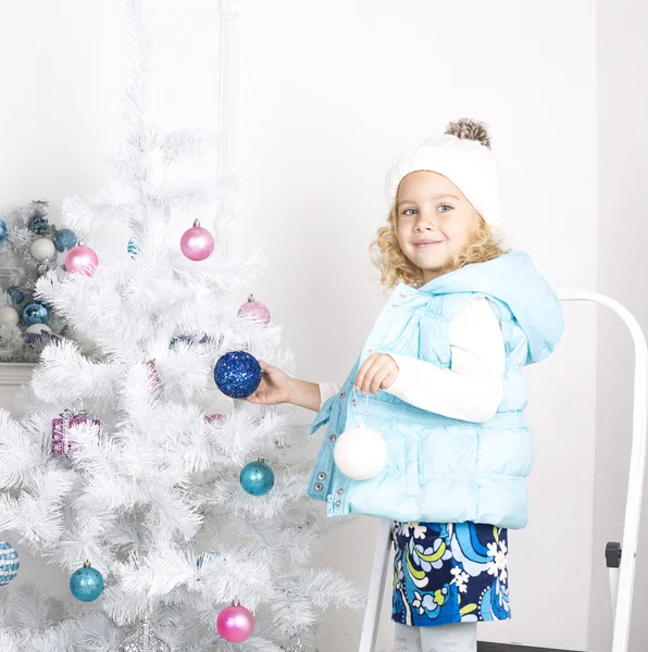 Funny little girl is decorating Christmas tree — Stock Photo, Image