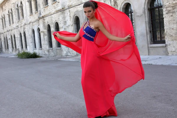 Beautiful ladylike woman with dark hair  in luxurious red dress — Stock Photo, Image