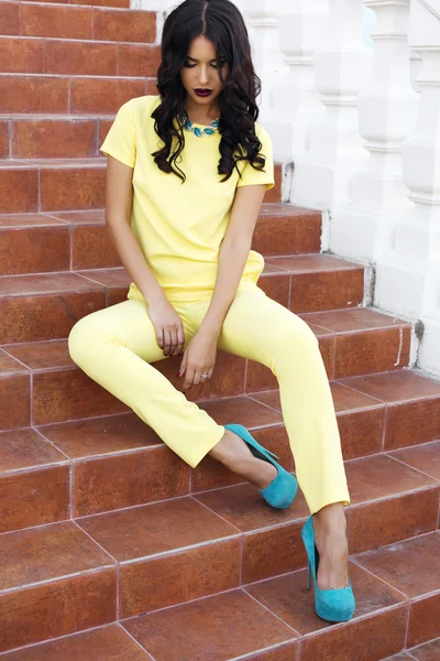 Beautiful woman with black hair in elegant yellow suit — Stock Photo, Image