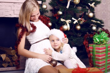 ihale ile hamile annesi bir Noel ağacı yanında küçük kız fotoğrafı