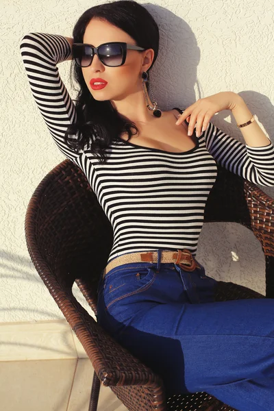 Sexig tjej med mörkt hår i solglasögon poserar på balkong — Stockfoto