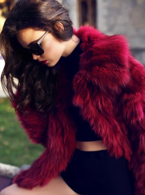 moda kırmızı kürk manto ve güneş gözlüğü koyu saçlı seksi kız