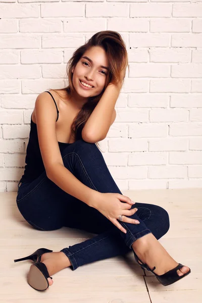 Foto de moda de la hermosa chica sonriente con el pelo oscuro usando jeans —  Fotos de Stock
