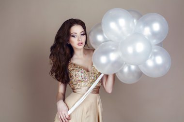 Beyaz balonlar tutan lüks elbiseli güzel esmer
