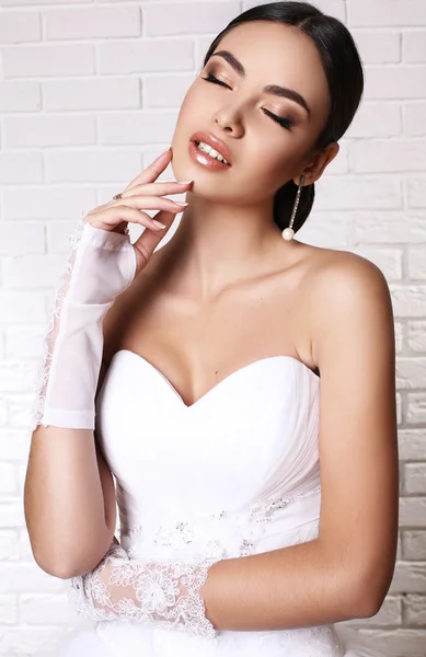 Mooie bruid met donker haar in elegante bruiloft jurk en handschoenen — Stockfoto