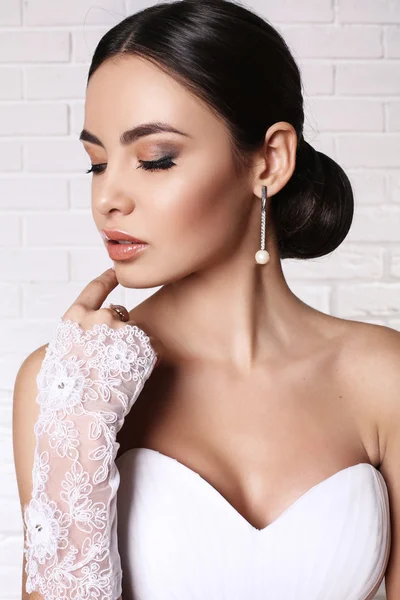 Schöne Braut mit eleganter Frisur trägt Hochzeitskleid — Stockfoto
