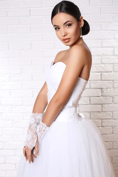 Bella sposa con i capelli scuri in elegante abito da sposa con accessori — Foto Stock