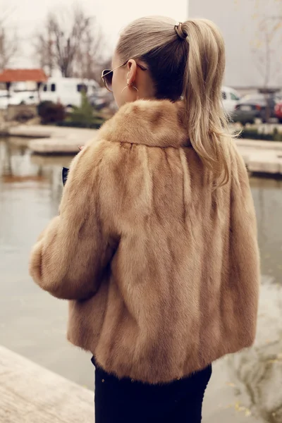 Mädchen mit blonden Haaren trägt luxuriösen Pelzmantel — Stockfoto